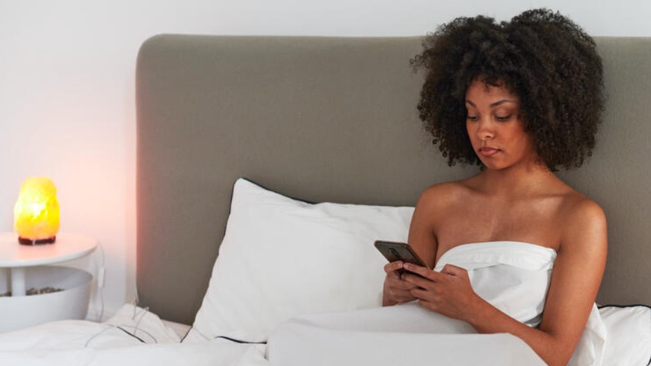 a lady sexting in bed